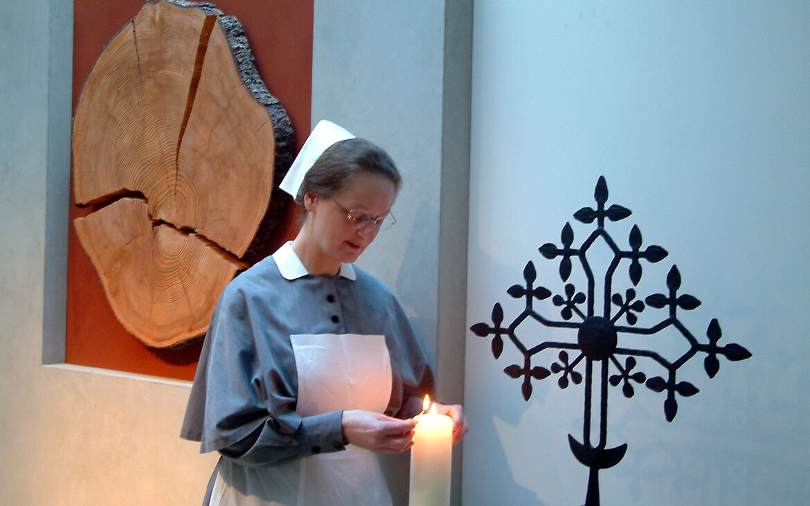 Schwester Renate zündet Kerze an